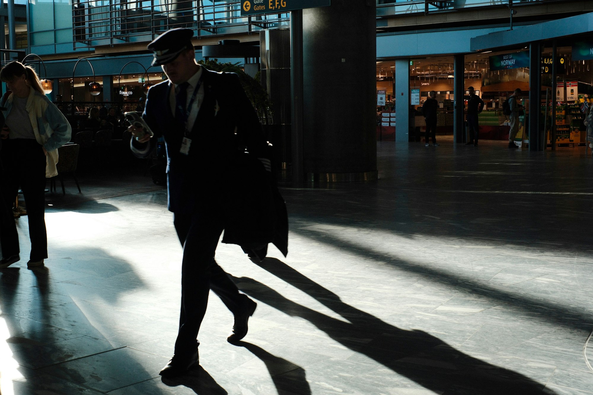 Business traveler checking their phone while walking through an airport terminal
